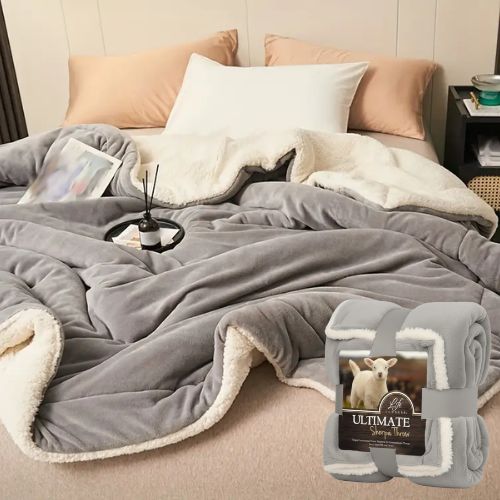 Siva deka od mikrovlakna s krznom složena na krevetu s prikazom pakiranja – Life Comfort Sherpa Throw