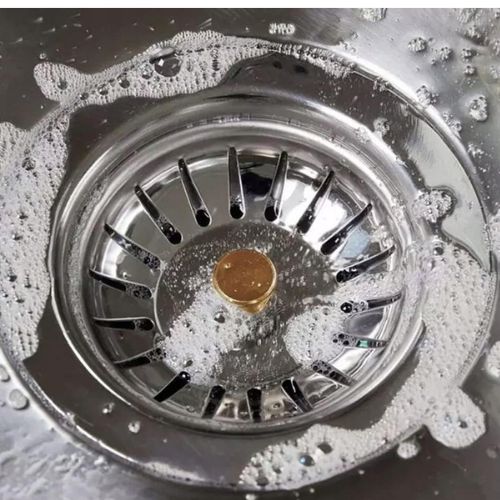 Metalni čep za sudoper sa sitom umetnut u odvod, tijekom upotrebe s vodom i sapunicom