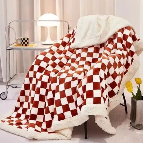 Crvena kockasta sherpa deka 3 kg s bijelim krznenim obrubom na naslonjaču