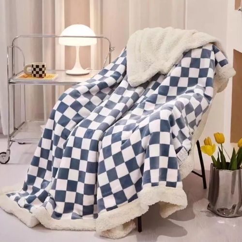 Plava kockasta sherpa deka 3 kg s bijelim krznom na naslonjaču u dnevnoj sobi